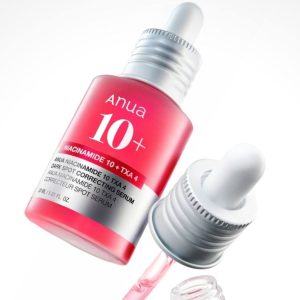 Pink skincare serum bottle with a dropper, labeled Anua 10+ Niacinamide (cosmetic product).